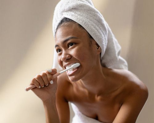 woman brushing her teeth on textured background