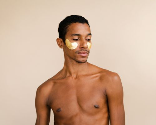 Man wearing gold under-eye skincare patches