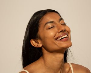 Woman smiling with glowing skin in sunlight