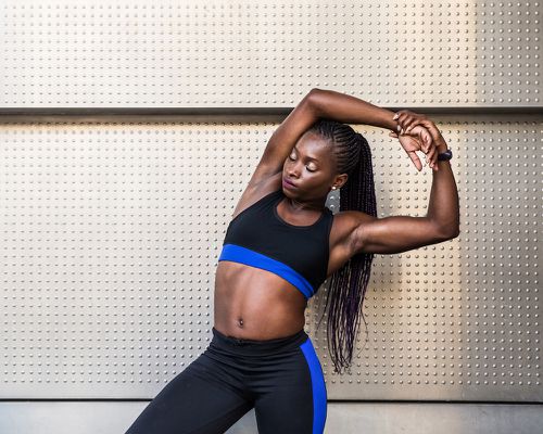 woman stretching against silver wall