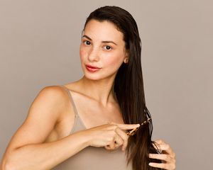 woman combing through ends of hair 