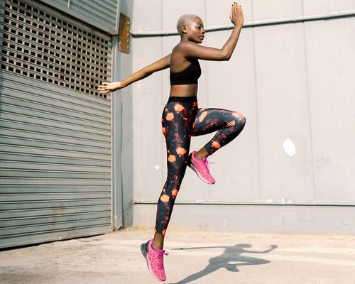 Woman in fitness clothes jumping mid-air