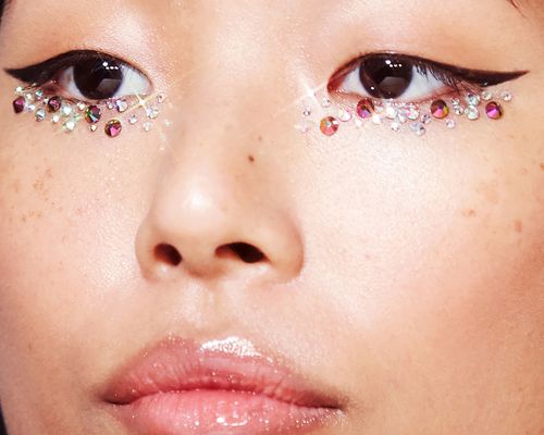 Close up of a woman with sparkly makeup under her eyes