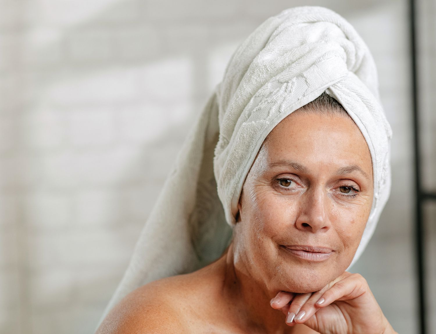 woman in bathroom wearing a hair towel