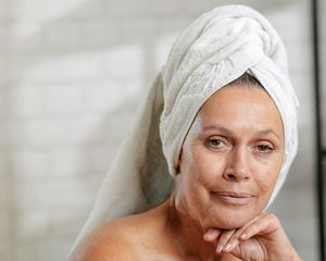 woman in bathroom wearing a hair towel