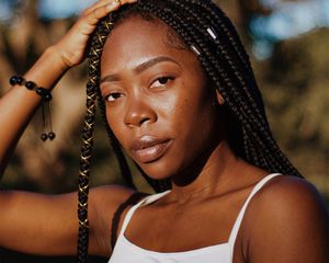 young woman standing in sunlight golden hour