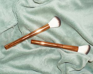 makeup brushes on light green background