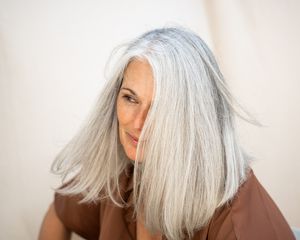 woman with shiny silver hair on white background