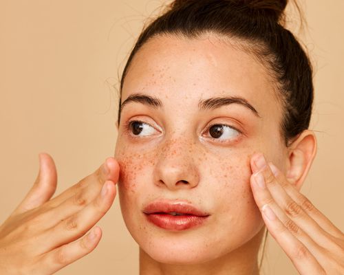 Woman practicing facial massage on her cheeks