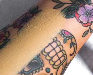 Close up of a tattooed forearm, a swatch of foundation down the center