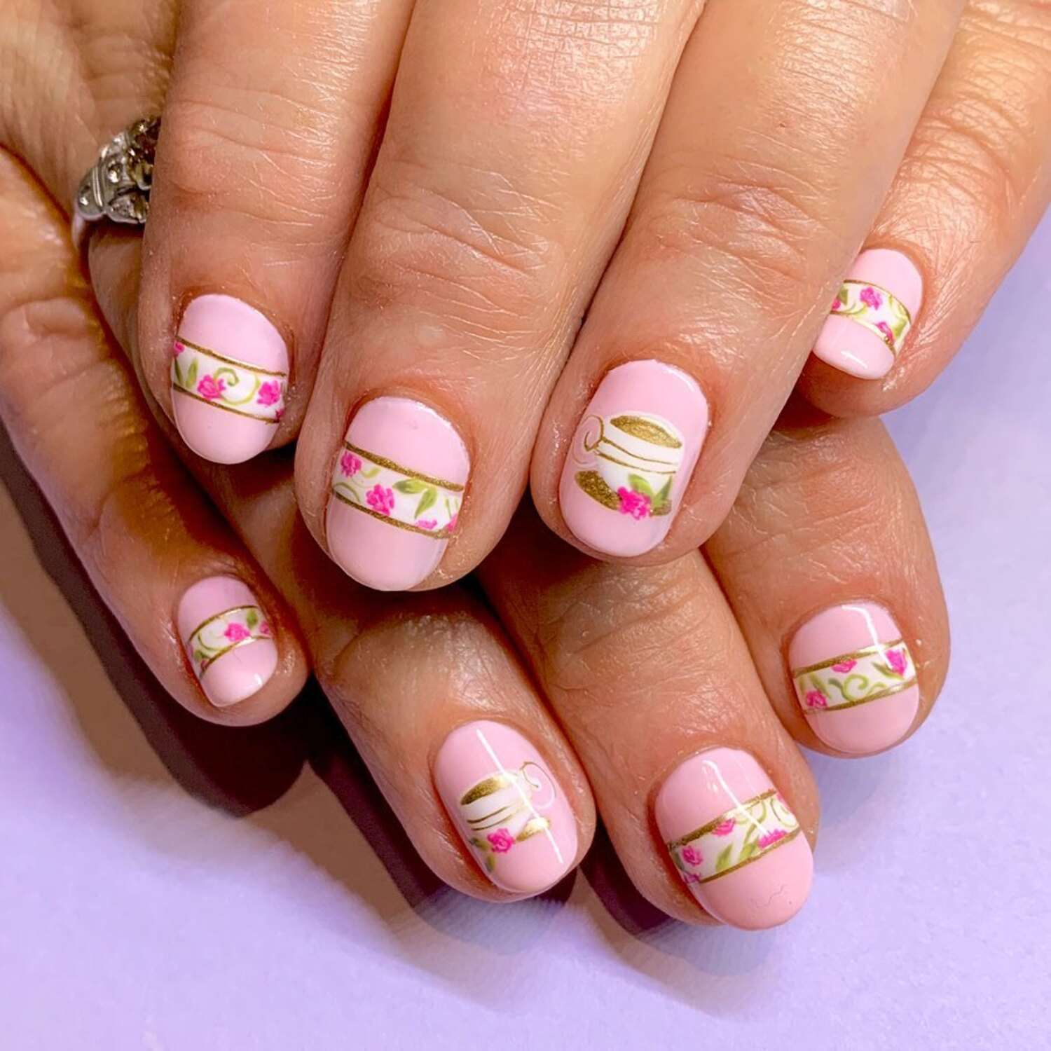 A baby pink manicure with a dainty tea party motif