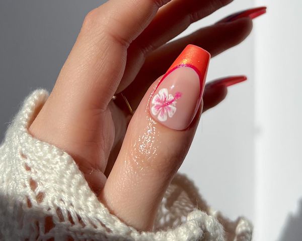 An orange French thumb nail with a hibiscus accent