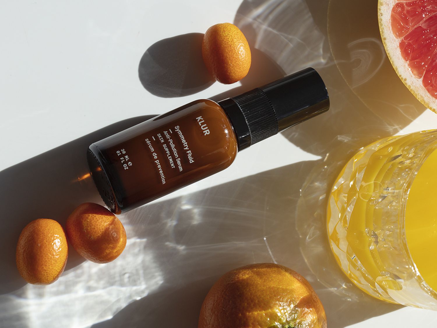 bottle of vitamin c serum surrounded by oranges