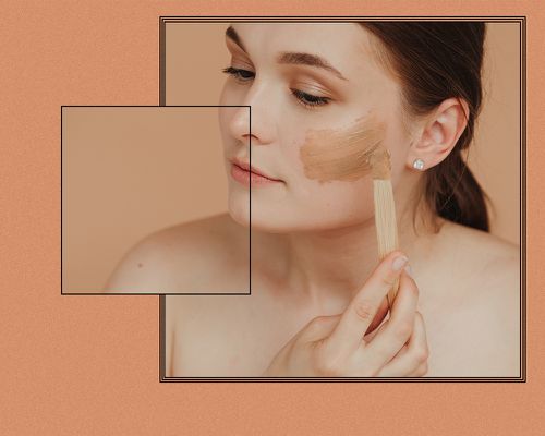 Woman applies a skincare mask to her face.