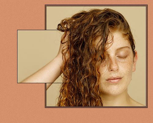 Close up of a woman grabbing her wet, wavy red hair.