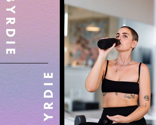 A woman sipping a water bottle during a workout