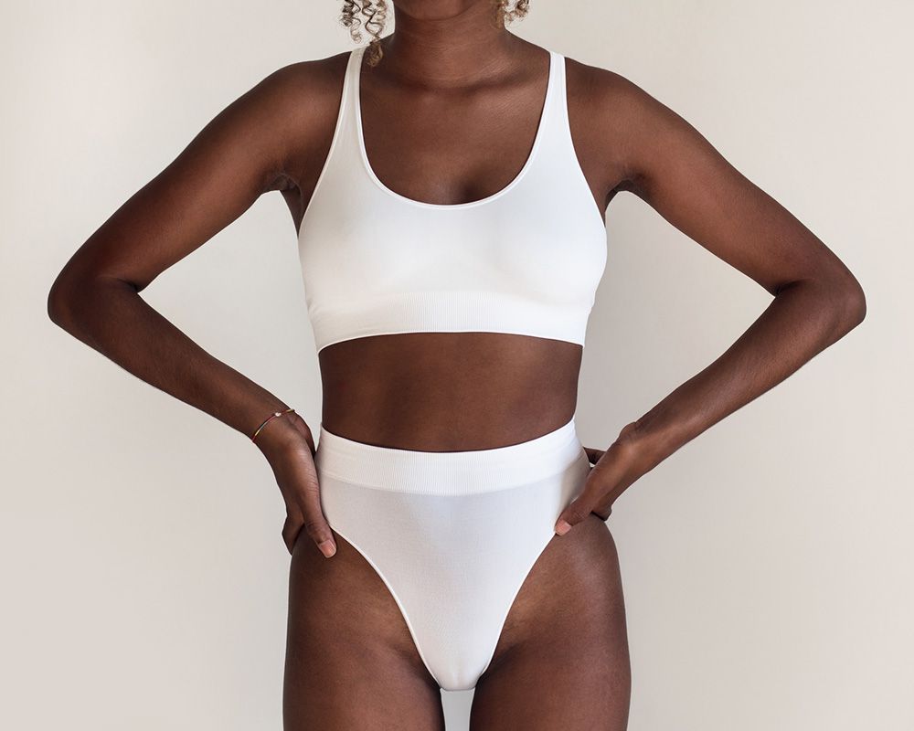 Woman in white bathing suit with arms on hips