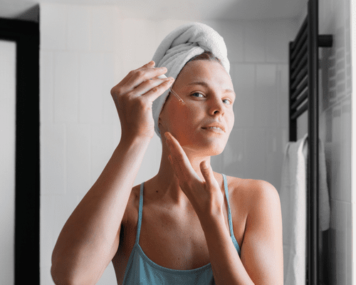 Close up of a woman applying facial serum