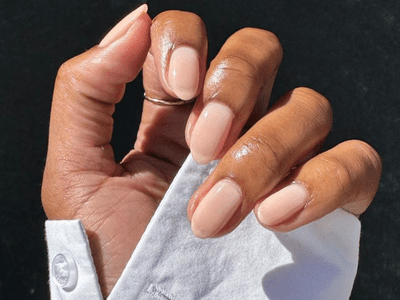 Hand with white shirt and sheer pink nails