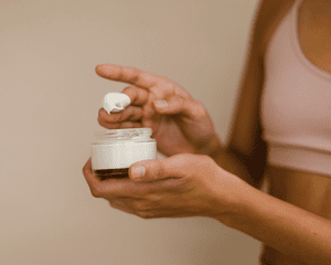 Hands holding a jar of moisturizer cream