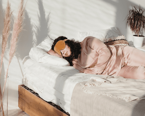 Woman in bed sleeping with an eye mask on