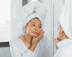 woman wearing hair towel and looking in mirror