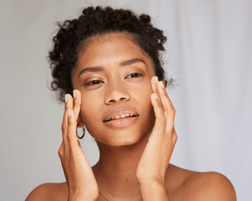 Close up of woman with clean skin touching her face