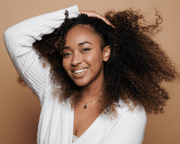 A woman with her hand in her curly hair