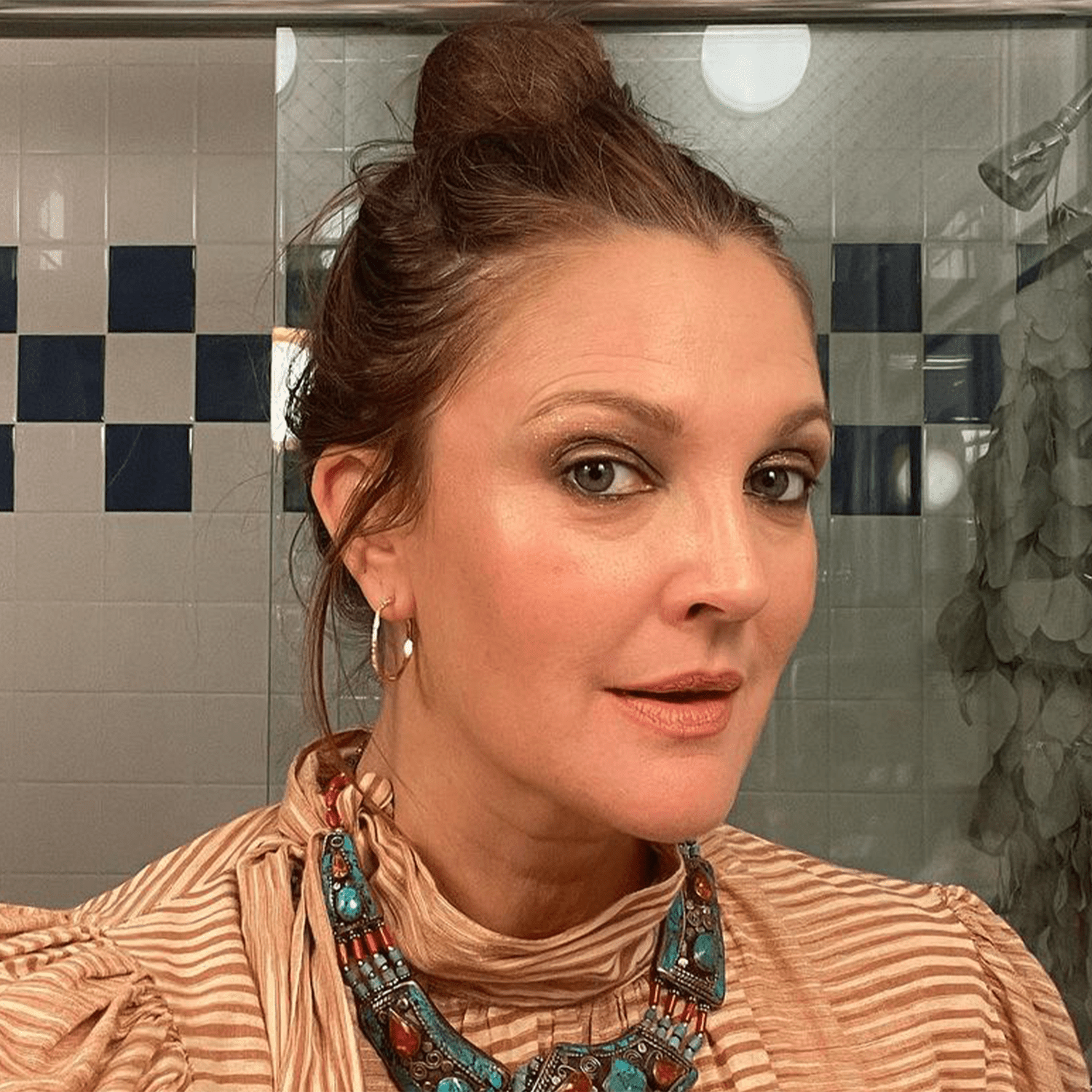 Drew Barrymore wearing loose bun and light makeup 