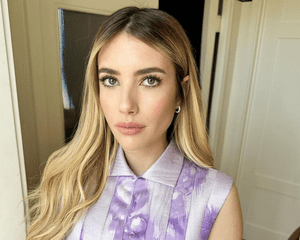 Emma Roberts with blonde highlights and a purple dress