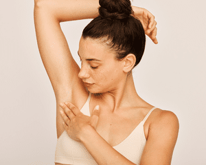 A woman with her arm up as she touched her underarm