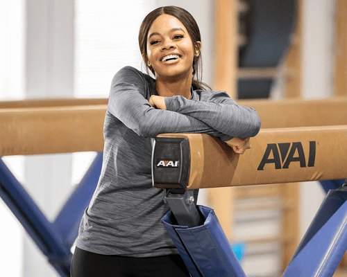 Gabby Douglas standing in gymnastics gym