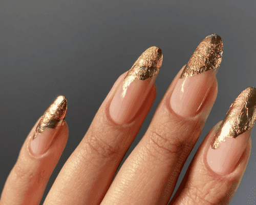 Close up of a manicure with gold foil tips