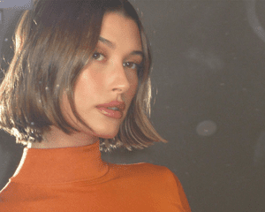 Hailey Bieber in an orange turtleneck