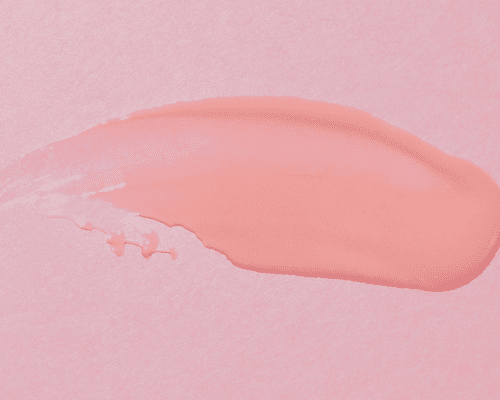 swatch of hair wax on pink background