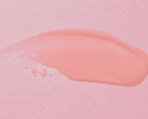 swatch of hair wax on pink background