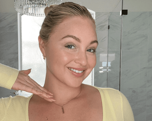 iskra lawrence wearing slicked back bun and yellow top and neutral makeup