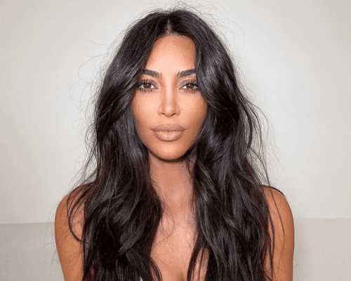 kim kardashian with messy long hair against white background