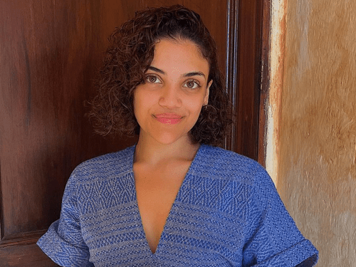 laurie hernandez wearing blue top and curly hair