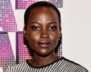 Lupita Nyong'o wearing purple eyeshadow and frosted lips