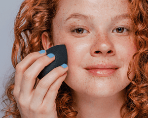 woman applying makeup with a sponge