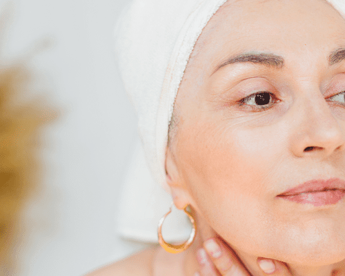 older woman with hair wrapped in white towel 