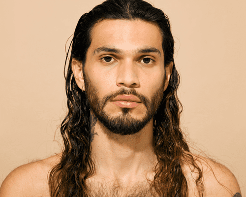 Close up of a male model with long wavy hair.