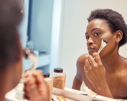 Close up of a woman microneedling her face