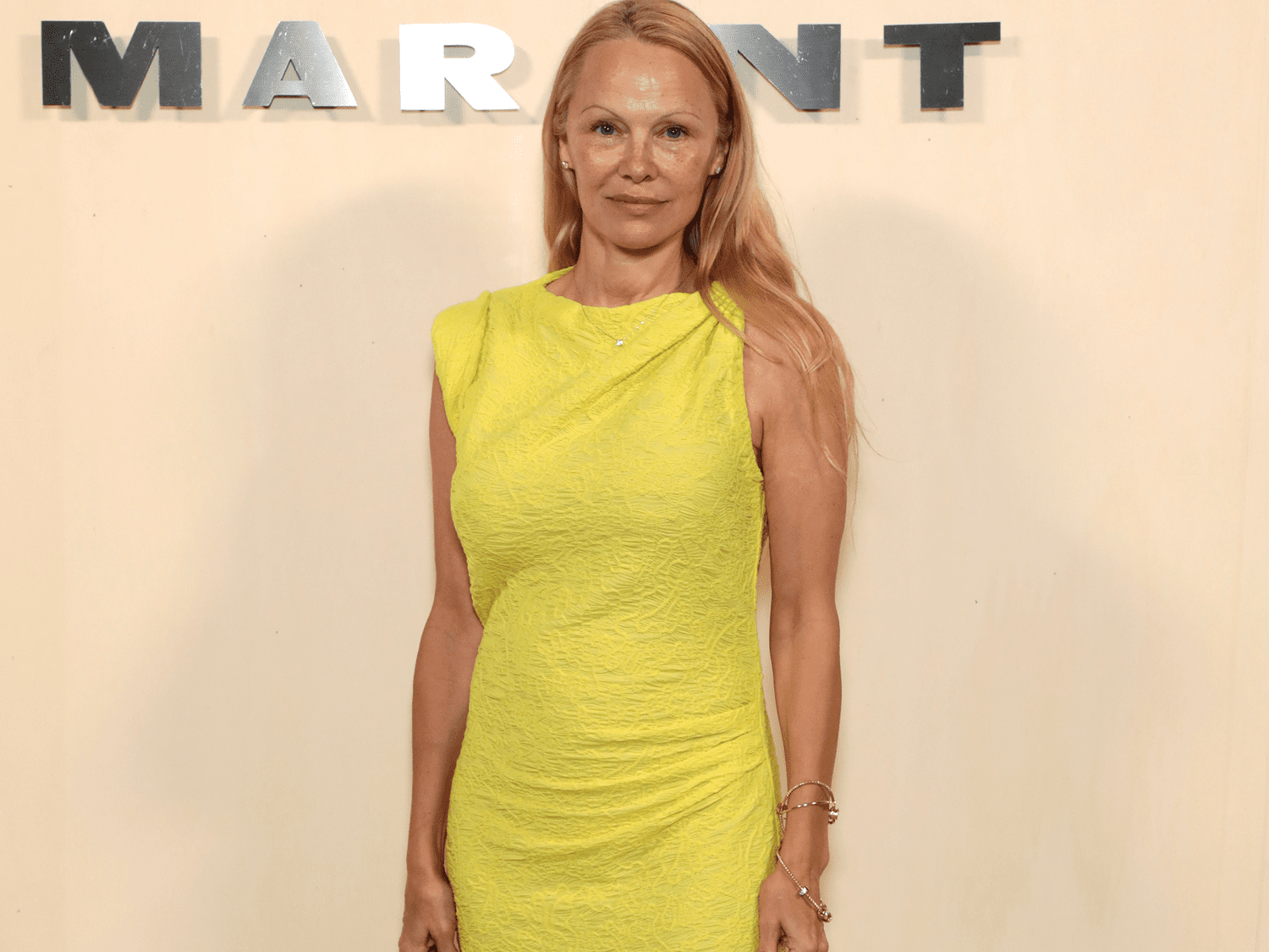 Pamela Anderson wearing no makeup and a yellow dress