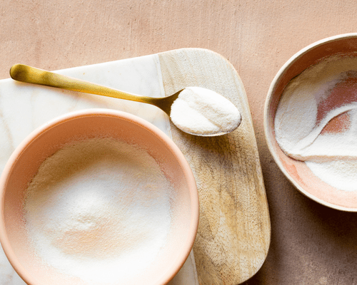 Composed image of two bowls and a spoon with collagen powder