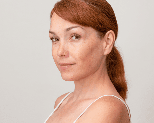 Up close of a woman with her red hair pulled back into a ponytail.