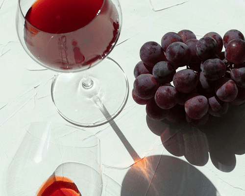 Close up of grapes and two wine glass.