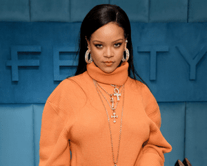 Rihanna wearing an orange sweater 