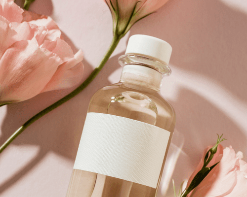 Close up of a bottle with roses around it 